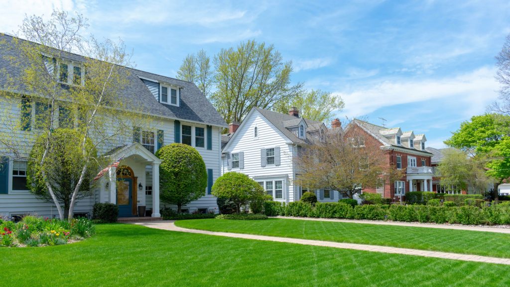 Wide green front lawns in traditional suburban residential neighborhood