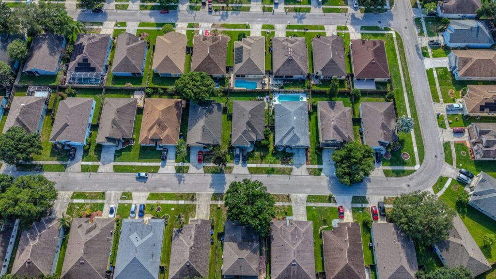 Aerial view of a neighborhood of similar single-family homes with small yards
